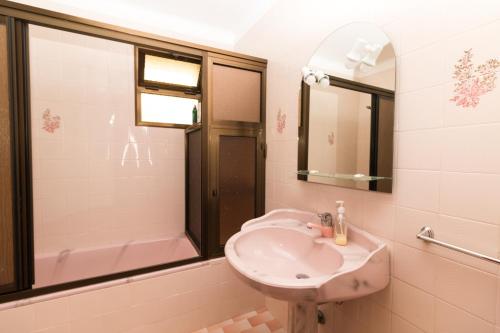 a bathroom with a sink and a mirror and a tub at Monte Vista Hermosa in Funchal