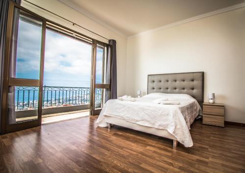 a bedroom with a bed and a large window at Monte Vista Hermosa in Funchal
