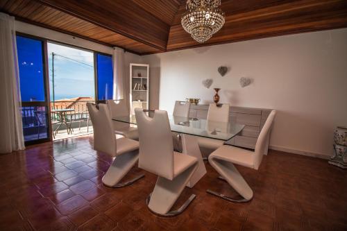 a dining room with a glass table and chairs at Monte Vista Hermosa in Funchal