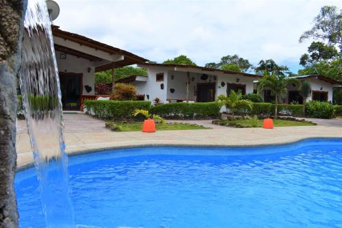 a swimming pool in front of a house at Piedras Blancas Lodge in Puerto Ayora