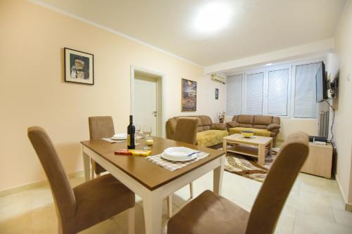 - un salon avec une table et une salle à manger dans l'établissement Apartman Centar 1, à Podgorica
