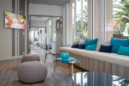 a living room with a couch and two chairs and a table at Mercure Thalasso & Spa Port Fréjus in Fréjus