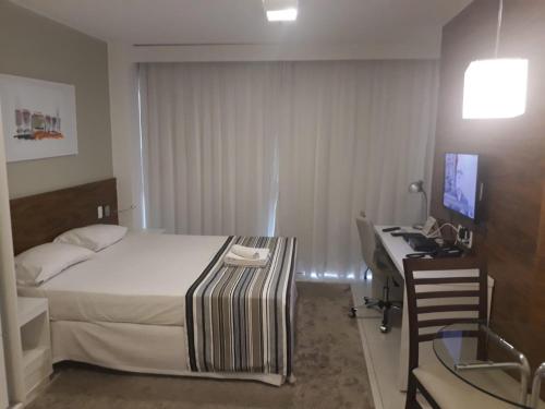 1 dormitorio con 1 cama y escritorio con ordenador en Fusion Executivo, en Brasilia