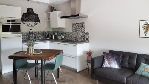 een keuken en een woonkamer met een tafel en een bank bij Osborg State in Buren