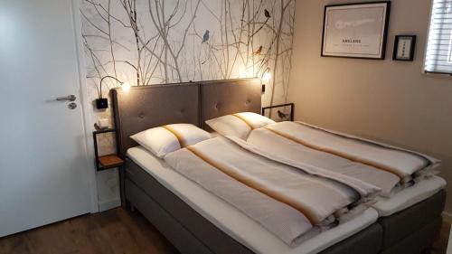 een bed met kussens in een kamer bij Osborg State in Buren