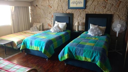 1 Schlafzimmer mit 2 Betten und bunter Bettwäsche in der Unterkunft Habitación amplia cerca de Andares in Guadalajara