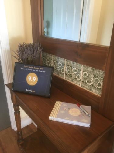 a laptop computer sitting on a table with a book at House on the Hill Bed and Breakfast in Huonville