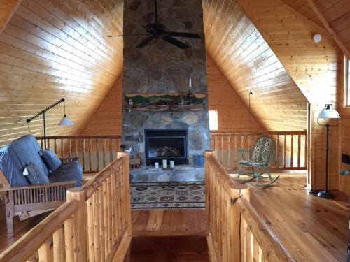 a living room with a fireplace in a log cabin at Wayward Cottage in Pisgah
