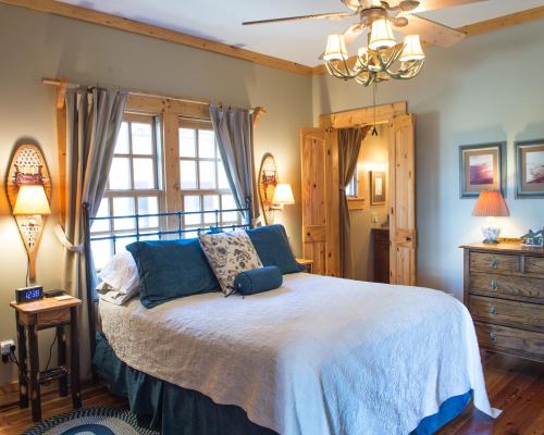 a bedroom with a large bed with blue pillows at Wayward Cottage in Pisgah