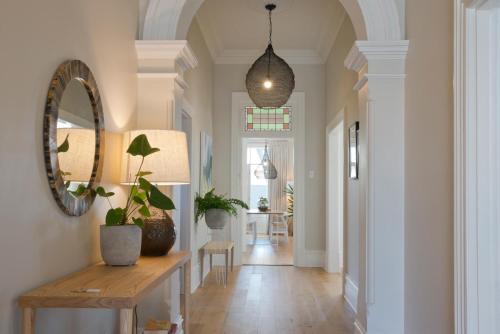a hallway with a mirror and a table with plants at Villa Maria Barossa Luxury Guesthouse in Tanunda