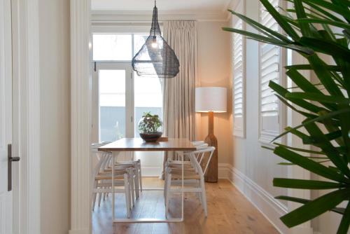a dining room with a table and chairs and a plant at Villa Maria Barossa Luxury Guesthouse in Tanunda
