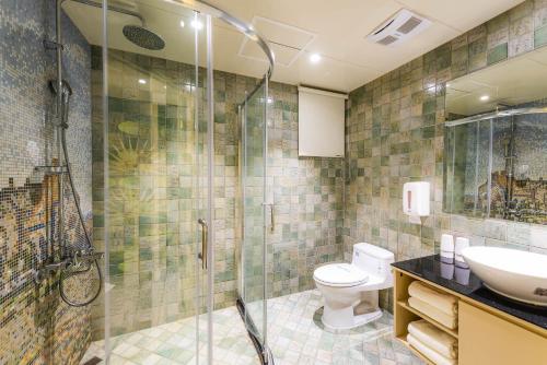 a bathroom with a shower and a toilet and a sink at Shichi Hotel in Kaohsiung