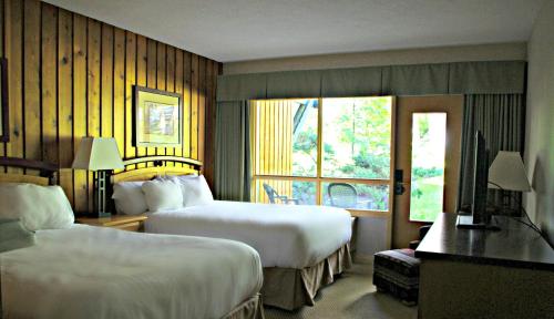 a hotel room with two beds and a window at Fairmont Hot Springs Resort in Fairmont Hot Springs