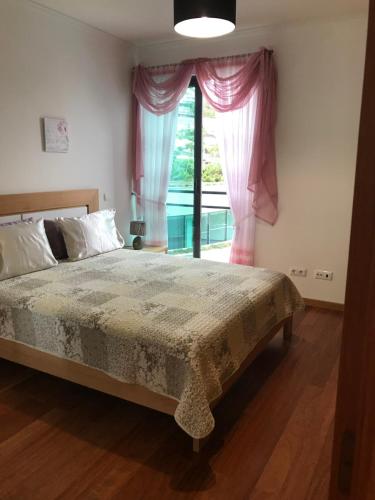 a bedroom with a large bed and a window at Lou-Jos in Funchal
