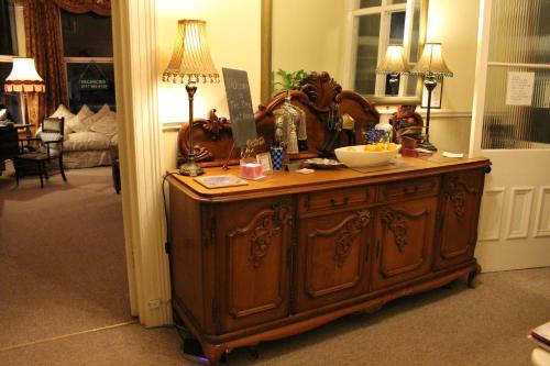 a room with a wooden cabinet with a bowl on it at The Elms Guest House Bristol in Bristol