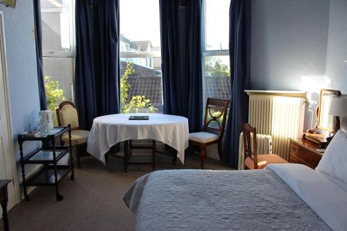 ein Hotelzimmer mit einem Tisch und einem Fenster in der Unterkunft The Elms Guest House Bristol in Bristol