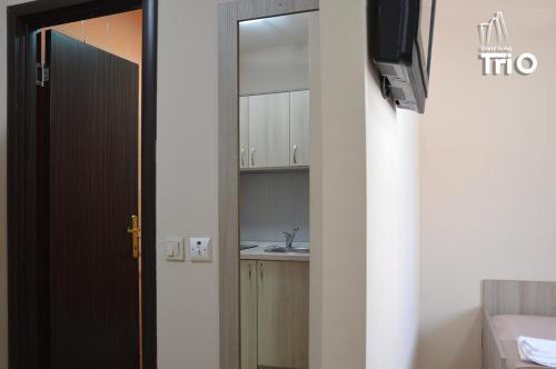 una puerta que conduce a un baño con lavabo en Garni Hotel Tri O en Kragujevac