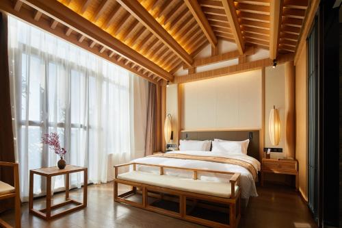 a bedroom with a large bed and a large window at 西安汉乐府酒店 - Xi'an Paradise Hotel of Han Dynasty in Xi'an