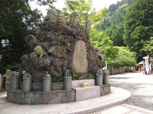 einen Steinbrunnen in einem Park mit Statuen darauf in der Unterkunft Togakubo in Isehara