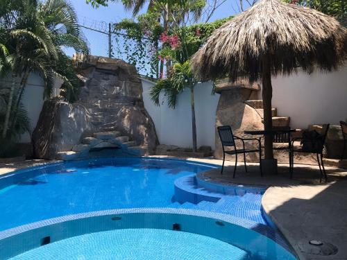 a swimming pool with a waterfall in a resort at Casa Bonita cerca de playa in Bucerías