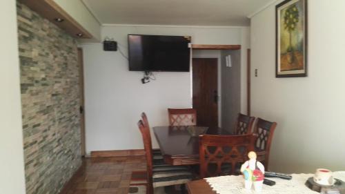a dining room with a table and a television on a wall at Departamento Frente al Mar in Viña del Mar