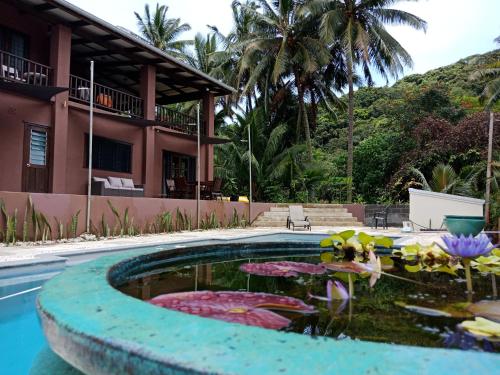einen Pool mit Teich vor einem Haus in der Unterkunft TE PUKA ESTATE Group & Function Venue in Rarotonga