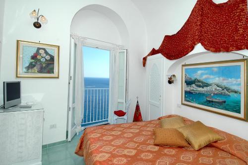 a bedroom with a bed with a view of the ocean at Hotel La Ninfa in Amalfi