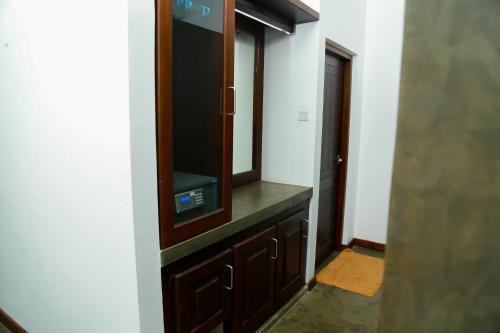 a room with a dresser with a tv and a mirror at Goyambokka Guesthouse in Tangalle