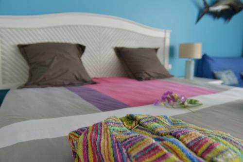 a bed with a blanket and flowers on it at studio "BLEU TURQUOISE" in Le Gosier