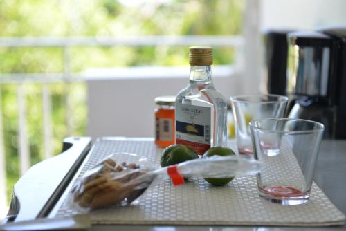 a bottle of alcohol and limes on a table at studio "BLEU TURQUOISE" in Le Gosier