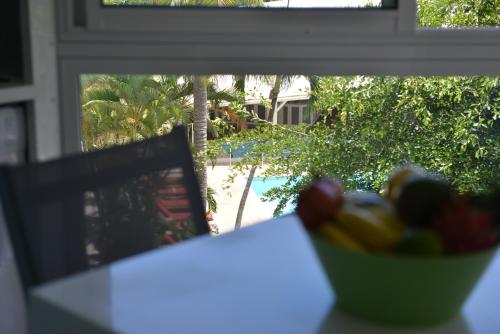 a bowl of fruit sitting on a table next to a window at studio "BLEU TURQUOISE" in Le Gosier