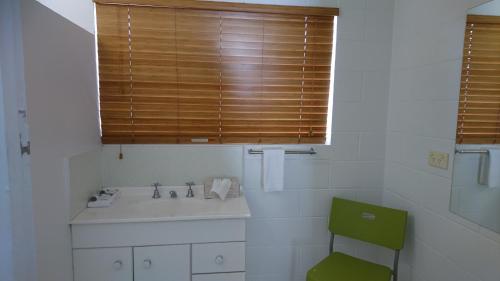 a bathroom with a sink and a green chair at Bororen Motel in Bororen