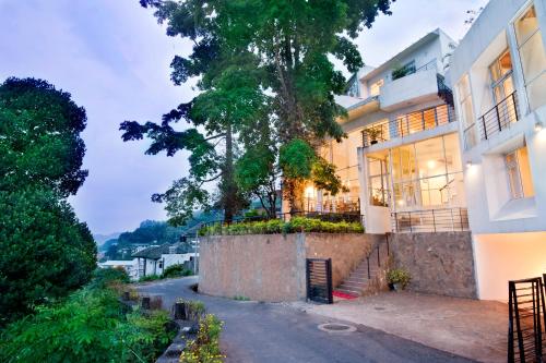 uma casa com uma árvore ao lado de uma rua em Hotel See Kandy em Kandy