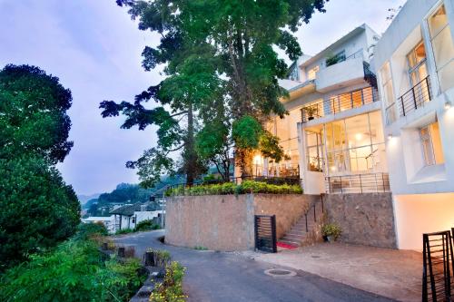 una casa con un árbol al lado de una calle en Hotel See Kandy, en Kandy