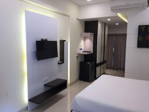 um quarto com uma cama e uma televisão na parede em Hotel Rezo's em Baga