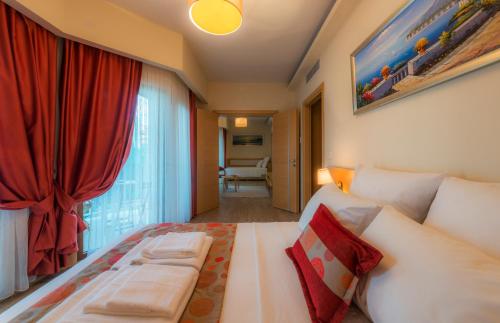 a bedroom with a large bed with a red curtain at Esida Hotel in Kucukkuyu
