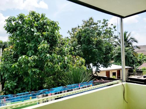 a view from the balcony of a house with trees at Baan Jaidee Guesthouse in Trat