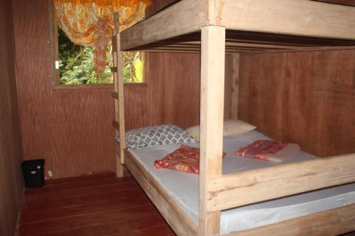 2 Etagenbetten in einem Holzzimmer mit Fenster in der Unterkunft Batad Transient House in Banaue