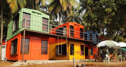 a house that is painted orange yellow and green at Iora Cottages in Alibaug