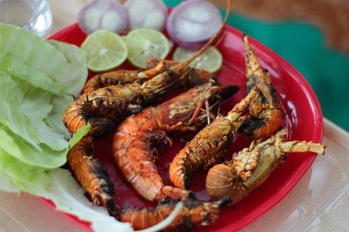 une assiette de homards sur une assiette rouge avec de la laitue dans l'établissement Iora Cottages, à Alibaug