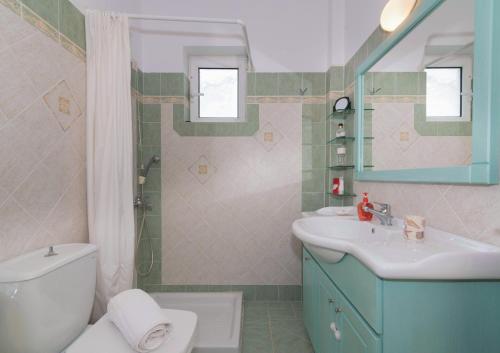 a bathroom with a white toilet and a sink at Villa Iliogenniti in Kalamaki