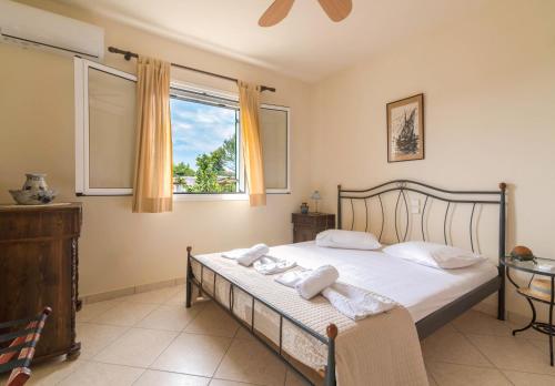 a bedroom with a bed with towels on it at Villa Iliogenniti in Kalamaki