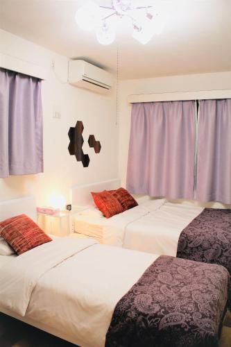 two beds in a room with purple curtains at Alo BnB 1 - Near UENO, AKIHABARA, SENSOJI, TOKYO SKY TREE - Self check-in in Tokyo