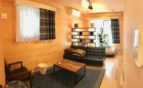 a living room with a green couch and a table at Alo BnB 1 - Near UENO, AKIHABARA, SENSOJI, TOKYO SKY TREE - Self check-in in Tokyo