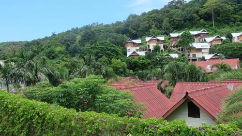 a group of houses with red roofs on a mountain at Rehab Hostel in Phi Phi Islands