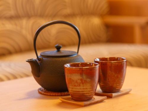 a tea pot and two cups on a table at Suiun in Hakone