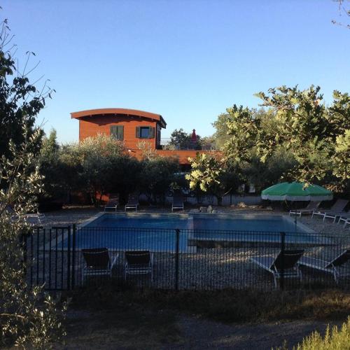 a pool with chairs and a building in the background at Suite Nid d'Amour et Spa privatif in Vogüé