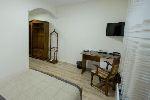 a bedroom with a desk and a bed and a chair at Hotel Villa Natali in Chişinău