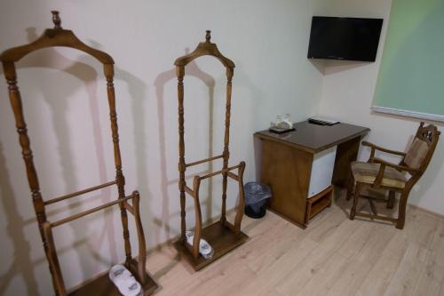 a room with two stands and a desk and a television at Hotel Villa Natali in Chişinău