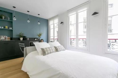 パリにあるJoie Paris St Germain des Prés - Jardin Luxembourgの白いベッドルーム(大型ベッド1台付)、キッチンが備わります。